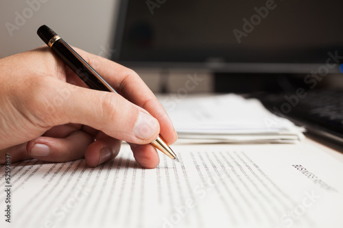 Photo: Man checking text on a business document Man checking text on a business document
