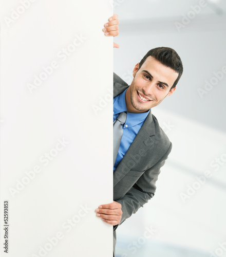 Photo: Smiling man showing a blank board Smiling man showing a blank board