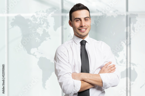 Photo: Confident businessman in front of a world map Confident businessman in front of a world map