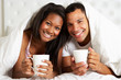 Photo: Couple Relaxing In Bed With Hot Drink Couple Relaxing In Bed With Hot Drink