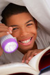 Boy Reading Book With Torch Under Duvet