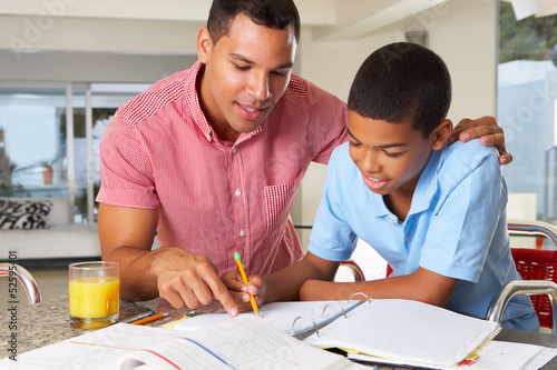 Photo: Father Helping Son With Homework In Kitchen Father Helping Son With Homework In Kitchen