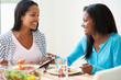 Photo: Two Women Eating Meal Together At Home Two Women Eating Meal Together At Home