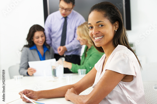 Photo: Portrait Of Businesswoman In Boardroom With Colleagues Portrait Of Businesswoman In Boardroom With Colleagues