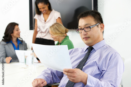 Photo: Portrait Of Businessman In Boardroom With Colleagues Portrait Of Businessman In Boardroom With Colleagues