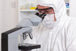 Lab technician looking through a microscope