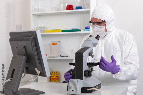 Photo: Lab technician looking at screen Lab technician looking at screen
