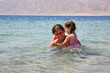 Photo: Father and baby daughter playing in the water. Father and baby daughter playing in the water.