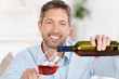 Foto: mann schenkt ein glas rotwein ein mann schenkt ein glas rotwein ein