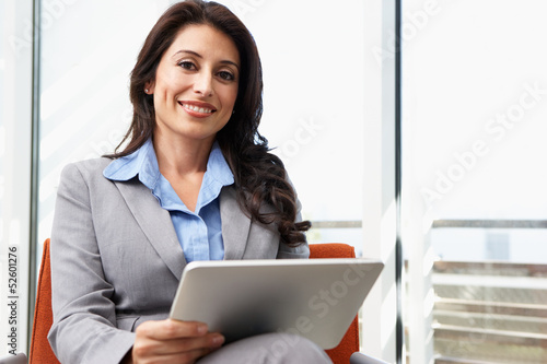 Photo: Businesswoman Using Digital Tablet In Office Businesswoman Using Digital Tablet In Office