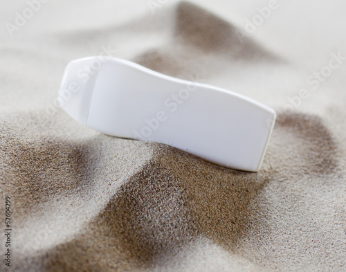 Photo: récipient de pommade dans le sable récipient de pommade dans le sable