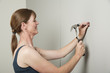 Woman using a hammer to bang a nail