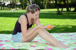 Junge Frau cremt sich mit Sonnenmilch ein