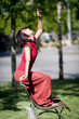 Danseuse sur un banc, bras levé vers le ciel.