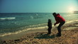 Mother and son playing on the sea shore, slow motion