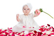 cute baby girl with flower sitting among rose petals