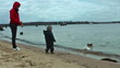 Mother and little boy on the beach feeding ducks
