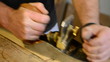 Luthier working in workplace with a wood planer
