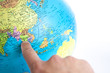 A Finger pointing to Thailand in a World Globe