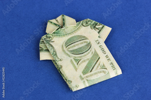 Photo: Dollar folded into shirt on blue background Dollar folded into shirt on blue background