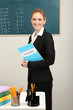 Portrait of teacher woman near chalkboard in classroom