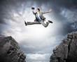 Businessman jumping over gap