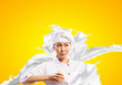 Asian female cook against milk splashes
