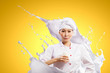 Asian female cook against milk splashes