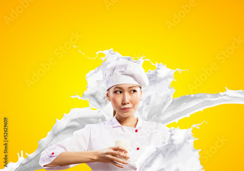 Photo: Asian female cook against milk splashes Asian female cook against milk splashes
