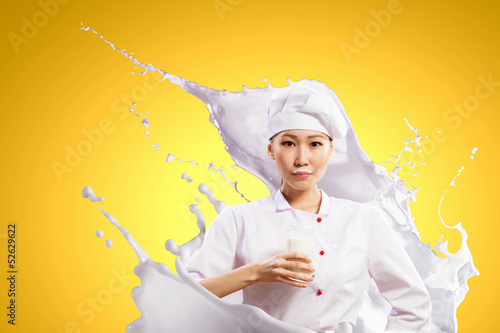 Photo: Asian female cook against milk splashes Asian female cook against milk splashes