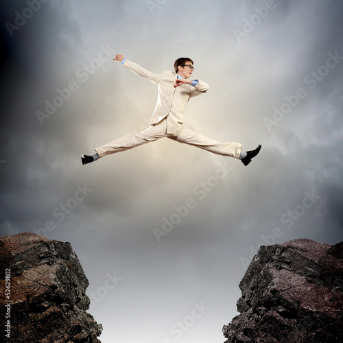 Photo: Businessman jumping over gap Businessman jumping over gap