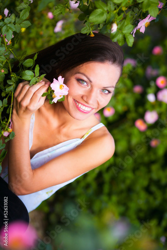 Photo: Woman near rose flower Woman near rose flower