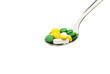 pills in a steel spoon on white with clipping path