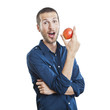 Cheerful beautiful man eating apple, isolated over white backgro