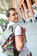 Smiling tourist with backback in train station