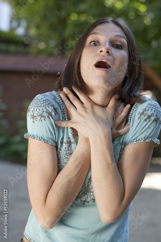 Photo: agitated young woman suffocating outdoors agitated young woman suffocating outdoors