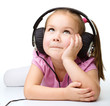 Photo: Cute little girl enjoying music using headphones Cute little girl enjoying music using headphones