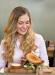 Photo: Woman Looking At Burger In Restaurant Woman Looking At Burger In Restaurant