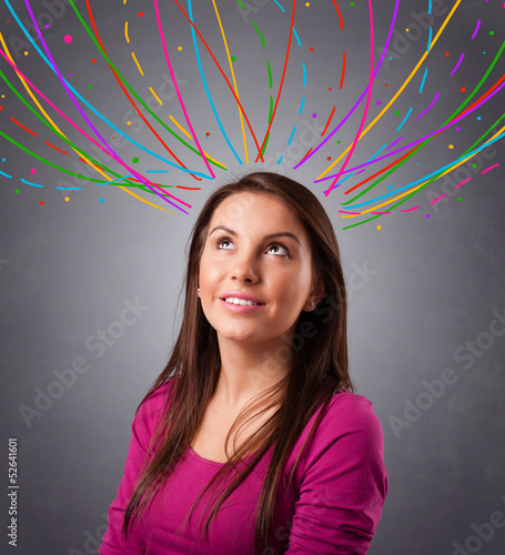 Photo: Young girl thinking with colorful abstract lines overhead Young girl thinking with colorful abstract lines overhead