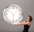 Attractive lady holding a huge clock