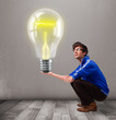 Attractive man holding realistic 3d light bulb