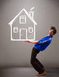 Young boy holding a huge drawn house