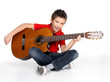 Smiling boy is playing the acoustic guitar