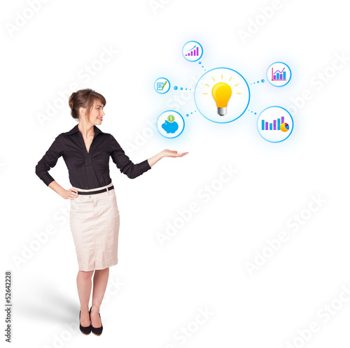 Photo: Young woman presenting light bulb with colorful graphs and diagr Young woman presenting light bulb with colorful graphs and diagr