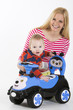 Charming boy with mother next to toy car