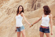 two girl holding hands on beach