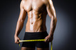 Photo : Muscular man measuring his muscles Muscular man measuring his muscles