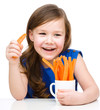 Photo: Cute little girl is eating carrot Cute little girl is eating carrot