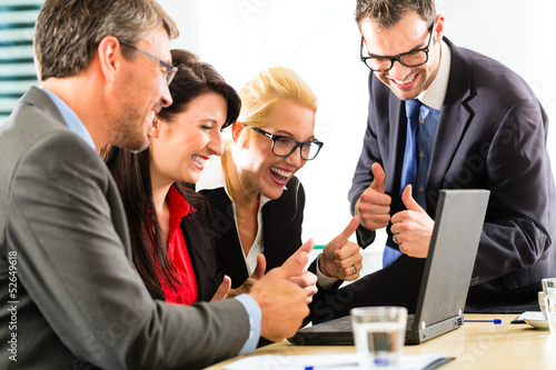 Photo: Business people looking at laptop with success Business people looking at laptop with success