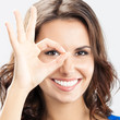 Foto: Young woman showing okay gesture, over grey Young woman showing okay gesture, over grey